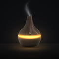 LUMUNO Aroma Diffuser in Walnut with cool mist rising and a warm amber glow