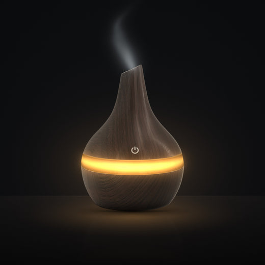 LUMUNO Aroma Diffuser in Walnut with cool mist rising and a warm amber glow
